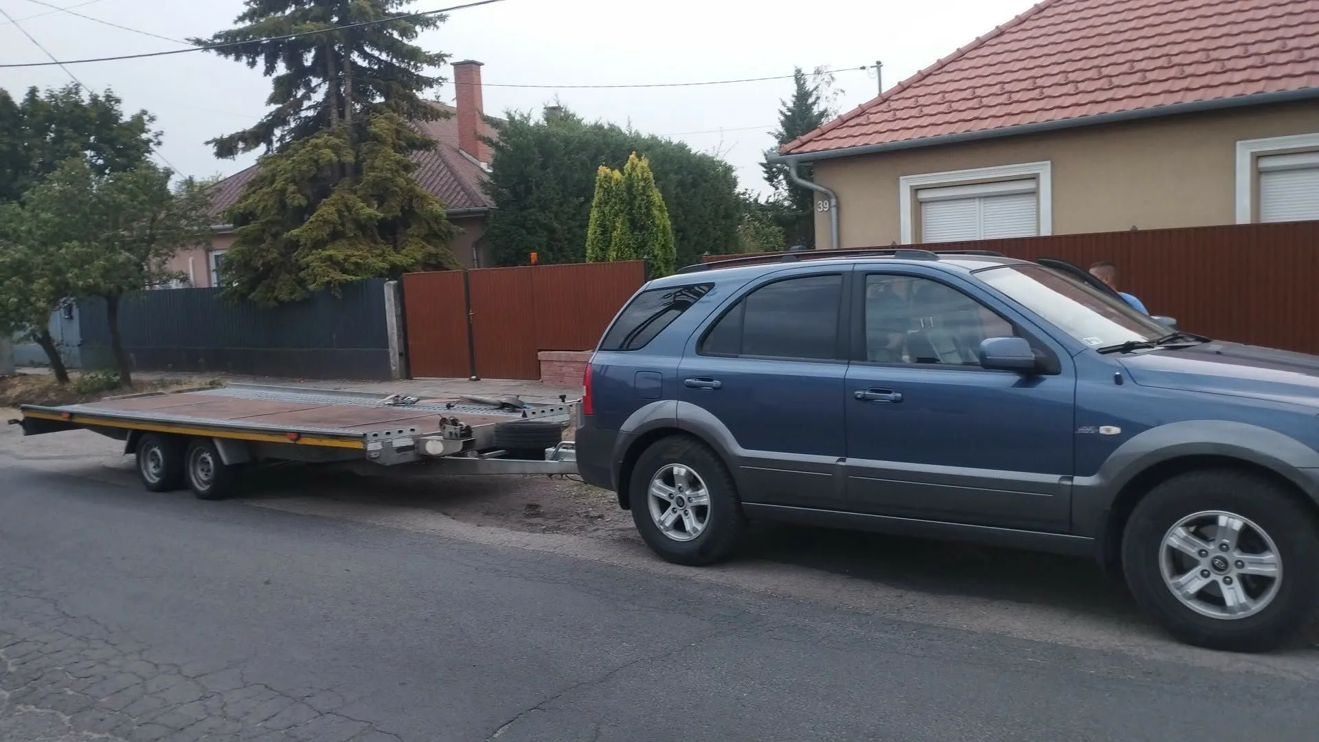 A Mária Autómentés vontató terepjárója az autószállító trélerrel egy utcán