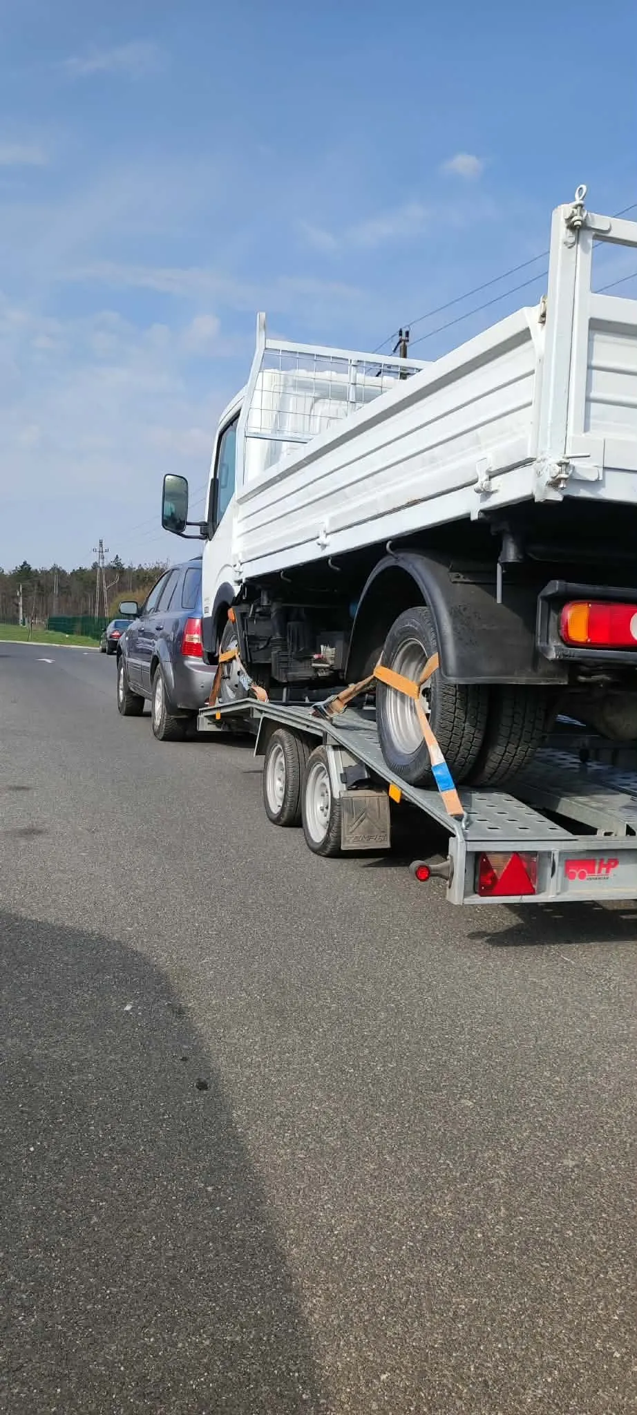 Kisteherautó a tréleren, hátulnézetből, országúton